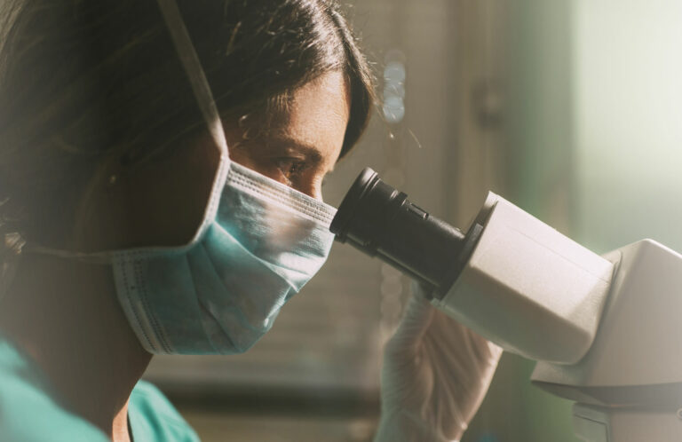 embrióloga mirando por un microscopio